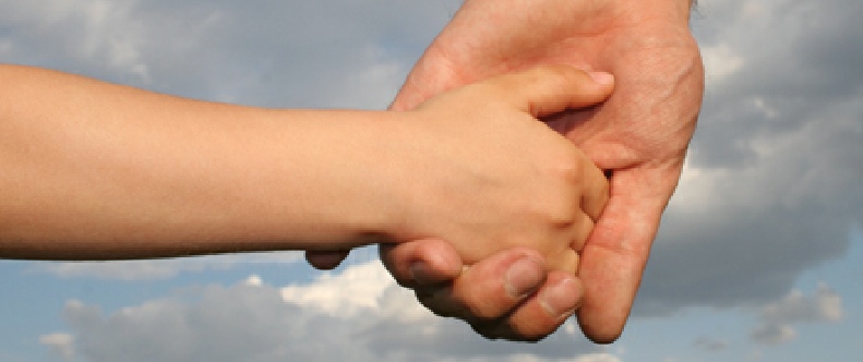 Eine erwachsene Hand hält eine Kinderhand